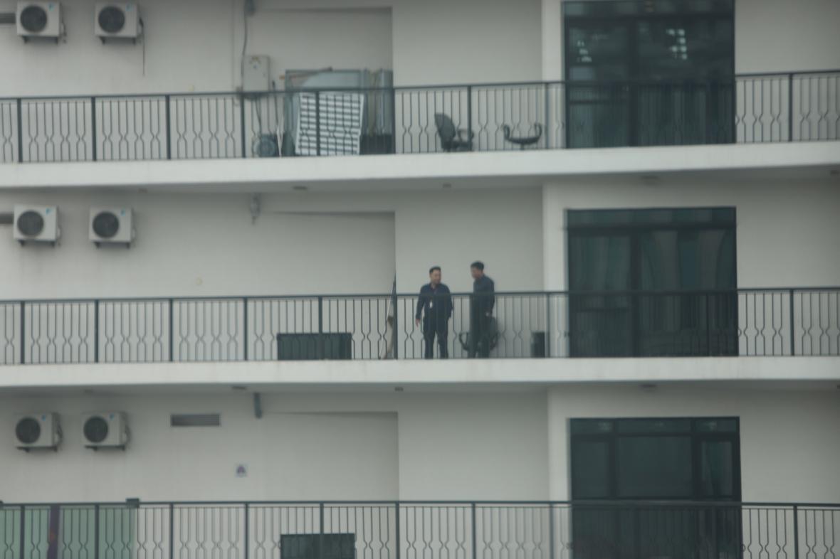 김정은 위원장이 묵고 있는 호텔 맞은편에 있는 건물에서 보안요원들로 보이는 사람들이 이야기를 하고 있다.