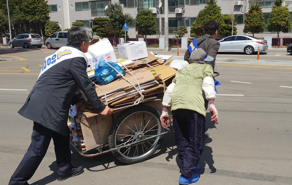 지난 달 30일 경남 통영에 민주당 후보의 선거유세를 지원하러간 장선배 충북도의회의장(왼쪽)과 최충진 청주시의회의원(오른쪽)이 한 노인이 끌던 폐지수레를 안전하게 이동시키고 있다./장선배의장 페이스북 캡쳐