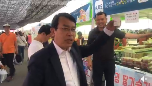 정의당 김종대 국회의원이 24일 대한민국도시농업박람회장에서 태희와의 SNS라이브 도중 지역 농업인이 만든 딸기음료를 홍보하고 있다.